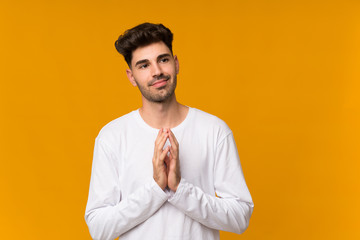 Young man over isolated orange background scheming something