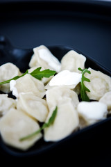 Raw fresh dumplings with meat or vegetarian dumplings with soy and spinach on black background. Food and cooking in the kitchen concept. Place for text. Copy space