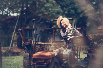 Young Woman Sitting On Abandoned Vehicle At Field