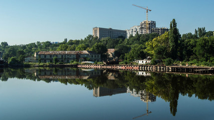 Fototapeta na wymiar Green park and buildings by the river