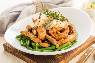 Roasted beef or pork meat slices with a side dish of green vegetables.