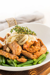Roasted beef or pork meat slices with a side dish of green vegetables.