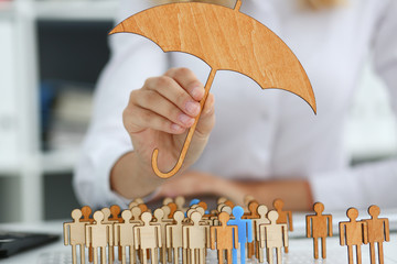 Smiling Business woman in hand holds a miniature umbrella in the hand of the topic of liability...