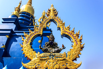 Fototapeta premium The giant statue holds a club and a crystal ball in his hand. The backdrop is a pagoda.