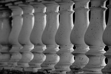 Fototapeta na wymiar Abstract row of white columns made of stone close-up, black and white image