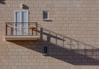 Light brown single modern balcony on paving stone wall