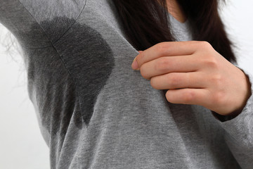 Close-Up Of Woman Smelling Armpit Against White Background