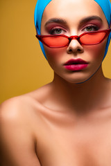 Fototapeta na wymiar sexy nude fashionable girl in trendy scarf and red sunglasses, isolated on yellow