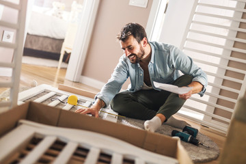 Man assembling a baby crib.