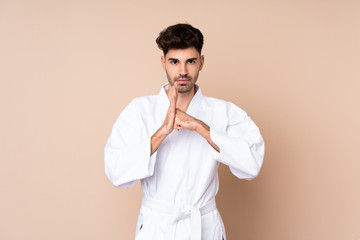 Young man over isolated background doing karate and saluting