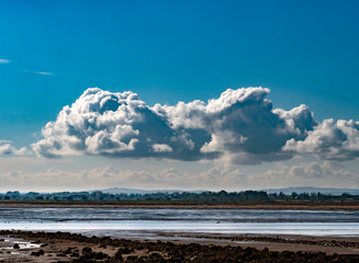 Dramatic puffy clouds over Irish coastal landscape