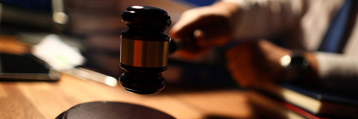 Focus on man in trendy tie wearing white shirt. Judge utility used to maintain order and pronounce a verdict in courtroom in front of many people. Strict court concept