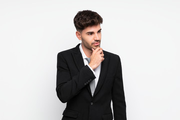 Young businessman over isolated white background thinking an idea