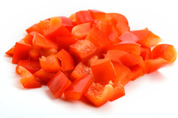 Heap of diced red bell pepper on white background
