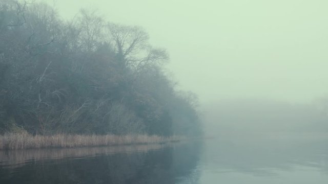 Eerie fog covered islands on lake in Winter