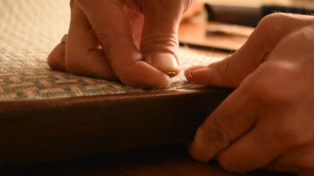 Master restores the antique armchair. Classical technology. Repair of furniture. Tighten the fabric