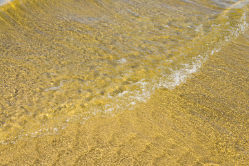 Sandy bottom of a river shot on a sunny spring day. Background for clear water.