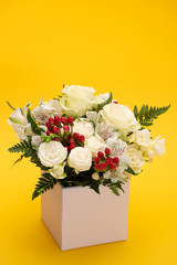 spring fresh bouquet of flowers in gift box on yellow background