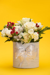 Spring fresh bouquet of flowers in festive gift box with bow on yellow