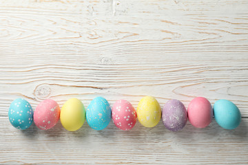 Multicolor Easter eggs on rustic wooden background, space for text
