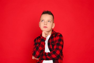Portrait of cute little boy on red background