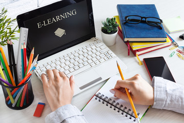Woman hands using laptop. Workplace with computer and books. E-learning, online education concept.