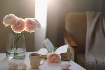 Spring home interior decor. Coffee cup, flowers, book. Decorated interior in living room. Blog,...