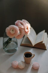 Spring home interior decor. Coffee cup, flowers, book. Decorated interior in living room. Blog, website or social media concept 