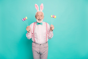 Excited retired old man celebrate easter party event hold colorful eggs hunt impressed scream wear...