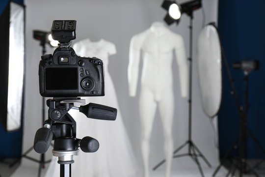 Taking pictures of ghost mannequins with modern clothes in professional photo studio, focus on camera