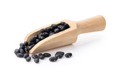 black beans in wood scoop on white background