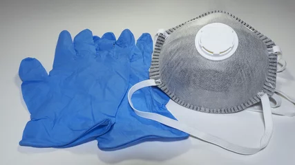  Set of FFP2 medical masks and disposable blue medical gloves. Face mask protection against pollution, virus, flu and coronavirus. Health care and surgical concept © Matteo Ceruti
