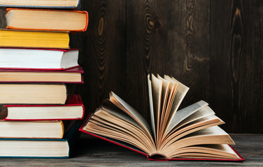Open book with a red cover on a blue background copy space. Book on a wooden table.