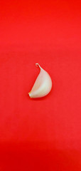 Garlic cloves are isolated on a red background.
