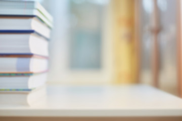 Background on the topic of training, education. Desk with books, bookcase and window in defocus. School concept or greeting card with the start of learning.
