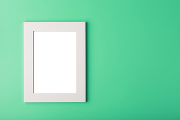 White photo frame with an empty space on a green background.