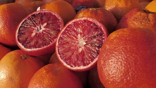 Close-up of a fresh blood oranges on fruit market. Boxes full of ripe oranges on farmers market. Organic fruit display in shop. Juicy crimson oranges at the greengrocer's stall. Harvest of blood