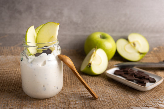 breakfast organic Yogurt in a jar with pure chocolate and fresh slices of apple