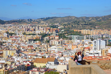 Malaga, Spain - March 4, 2020: Tourists from the Gibralfaro Castle contemplate the city of Malaga.