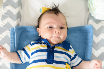 Bebé pequeño tumbado en camita de bebé