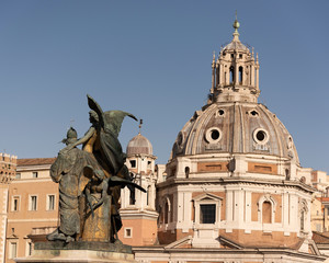 Fototapeta na wymiar They are two bronze statues representing a winged Victory, overlooking the church of the most holy name of Maria al Foro di Traiano, with the Trajan column, Rome, Italy.