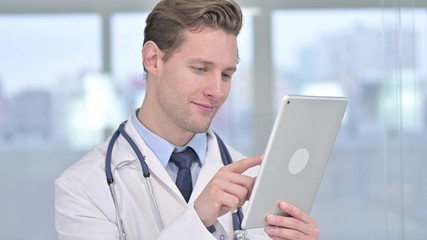 Fototapeta premium Portrait of Serious Young Male Doctor Using Tablet