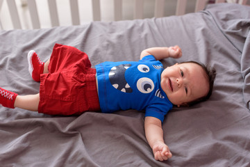 Bebé pequeño tumbado en camita de bebé