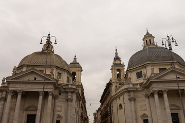 Fototapeta na wymiar Twin churches in Piazza del Popolo Rome, Italy. Santa Maria in Montesano and Santa Maria dei Miracoli from the second half of the seventeenth century
