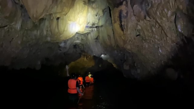 A family wading the waters of a subterranean cave as a colony of bats fly overhead, Following shot