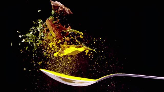 A Full Spoon Of exotic spice Flying up and Falling down on black background closeup in super slow Motion