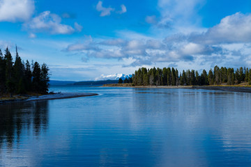 Yellowstone river entering yellowstone lake with snowy mountains