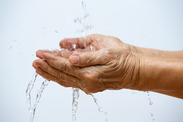 Senior woman washing her hands in white background, Close up & Macro shot, Selective focus, Prevention from covid19, Bacteria, Healthcare concept