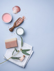 Fototapeta na wymiar natural organic cosmetics with pink Himalayan salt, soap and eucalyptus branch on a blue background