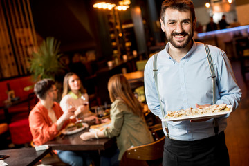 Portrait of the waiter carries dishes